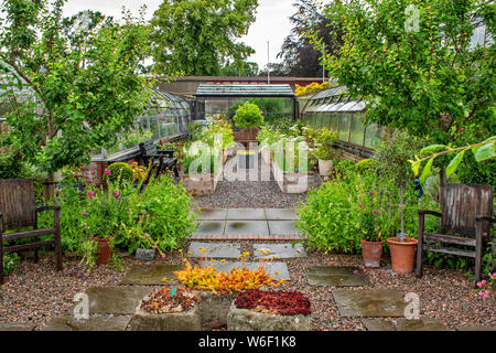 INVERNESS SCOTLAND THE BOTANIC GARDENS PATIO WITH CHAIRS GREENHOUSES AND FLOWERS IN WOODEN CONTAINERS Stock Photo