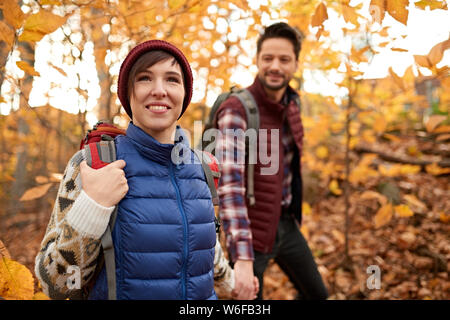 Attractive caucasian couple hiking through the forest in the fall in Canada Stock Photo