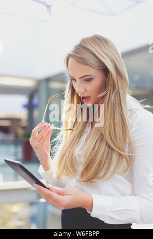 Blonde businesswoman amazed by financial results while using digital tablet Stock Photo