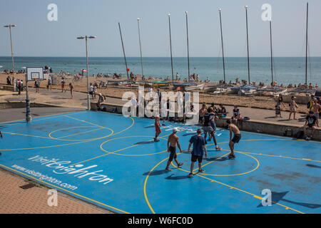 Basketball players enjoy the sunshine on Brighton Seafront, seaside town in the county of East Sussex, England, United Kingdom Stock Photo