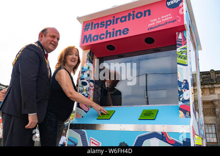 Edinburgh, Scotland, UK. 31 July 2019. Frank Ross, Lord Provost of Edinburgh  and Shona McCarthy, Chief Executive of of the Edinburgh Festival Fringe Society proclaimed the start of the 2019 Fringe by pushing the button on the new colourful arcade style Fringe Inspiration Machine on The Mound in Edinburgh today. The new Inspiration Machine is designed to help out audiences who might be having trouble deciding which shows to see from the diverse programme, by delivering three randomised suggestions of Fringe shows at the push of a button. Stock Photo