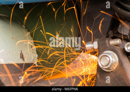 Close-up of Electric Grinder Cutting metal pipe with Bright Sparks tails Stock Photo