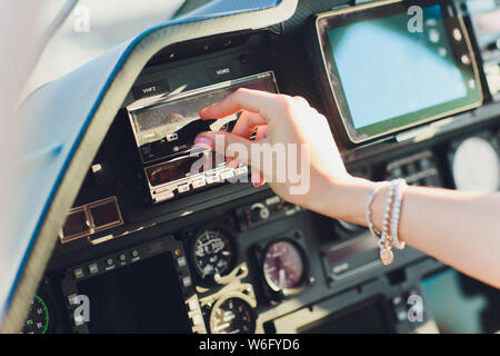 Female pilot in cockpit of helicopter before take off. Young woman helicopter pilot. Stock Photo