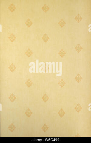 Abstract vertical beige floral pattern on a light yellow wall - fabric, texture, repetitive. Stock Photo