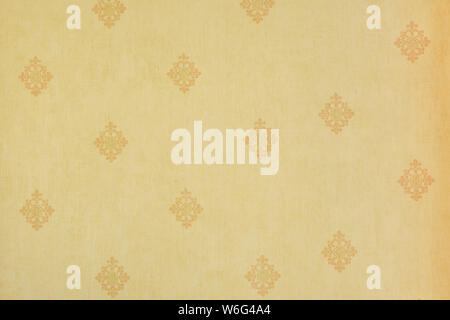 Abstract beige floral pattern on a light yellow wall - fabric, texture, repetitive. Stock Photo