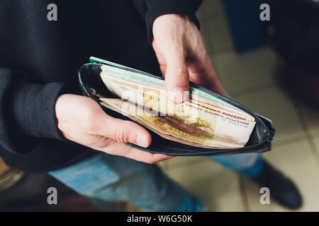 Hands take out russian rubles from wallet. Closeup on a man's hands as he is getting a banknote out of his wallet. Stock Photo