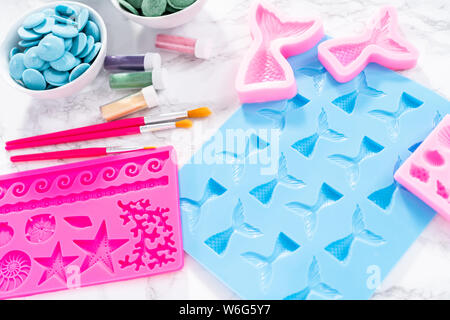 Flat lay. Ingredients to make chocolate mermaid molds from the chocolate chips. Stock Photo