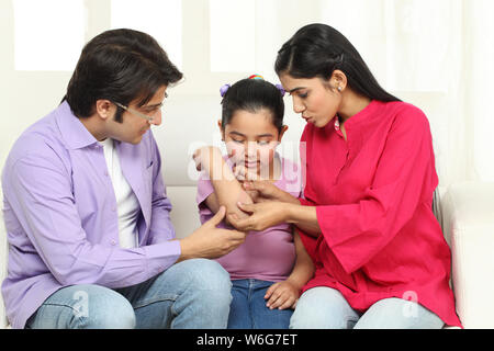 Mother putting bandage on daughter elbow Stock Photo