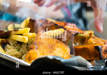 Delicious paneer, french fries and vegetble sizzler giving off smoke and steam Stock Photo