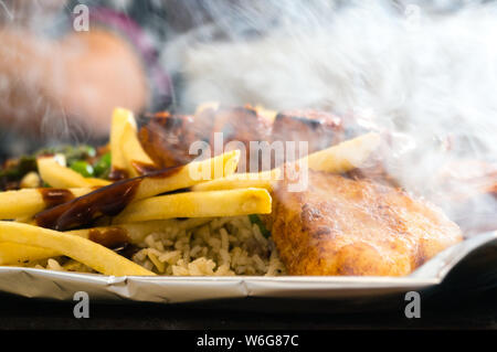 Delicious paneer, french fries and vegetble sizzler giving off smoke and steam Stock Photo