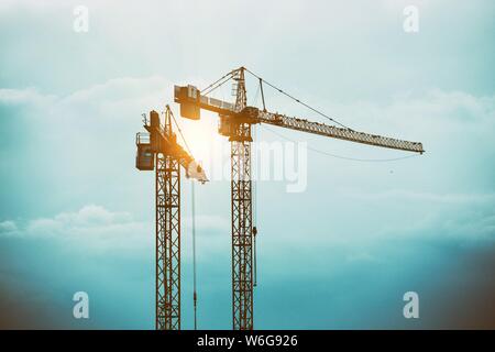 tower cranes against a stormy sky Stock Photo