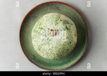 Crown prince winter squash on rustic green plate, overhead shot. Stock Photo