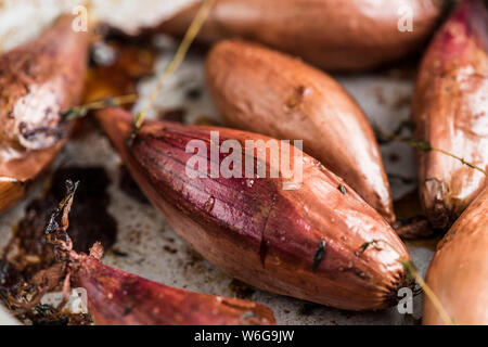 Banana shallots, roasted in the skins. Stock Photo