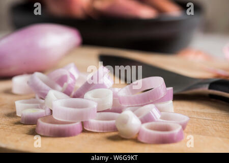 Banana and round shallots, peeled and sliced, with knife. Stock Photo