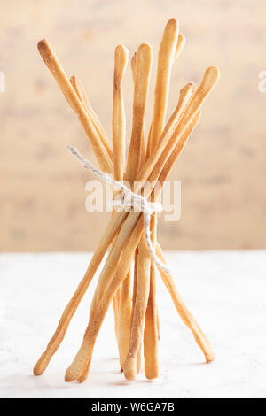 Rustic, home made bread sticks tied with coarse string in a bundle Stock Photo