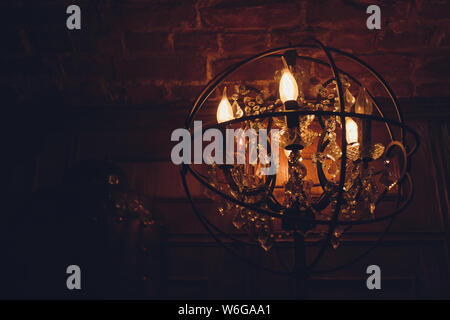 Standing brass chandelier with burning candles in shallow focus home setting. Stock Photo