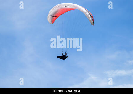 Paragliding - A colorful paraglider soaring high in blue sky above Lookout Mountain near city of Golden, Colorado, USA. Stock Photo