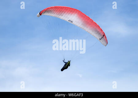 Flying In Blue Sky - Close-up view of a colorful paraglider flying high in blue sky above Lookout Mountain near city of Golden, Colorado, USA. Stock Photo