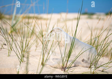Rubbish plastic disposable cup on sandy beach, plastic pollution Stock Photo