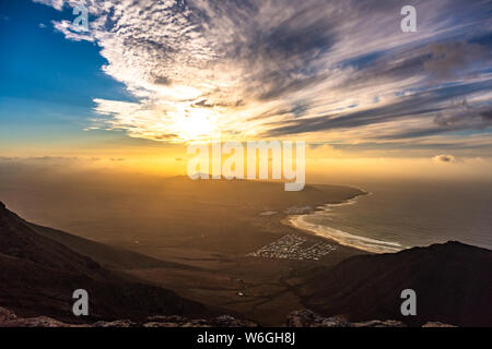 Amazing summer sunset over ocean resort beach Famara Lanzarote Canary Islands, Spain Stock Photo