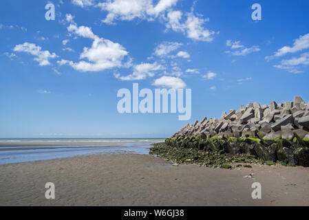 Mound type sea wall / seawall / dam made of concrete blocks, coastal defense at Grand-Fort-Philippe, Pas-de-Calais, Hauts-de-France, France Stock Photo