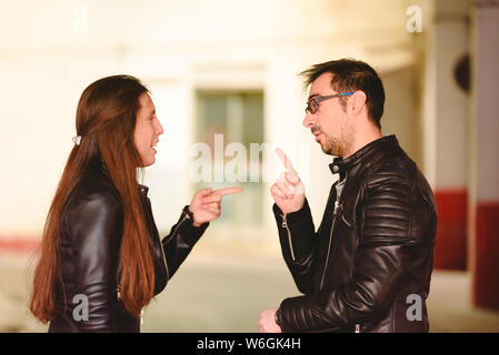 Angry millennial couple arguing and blaming each other of problem, frustrated about their relationship. Stock Photo