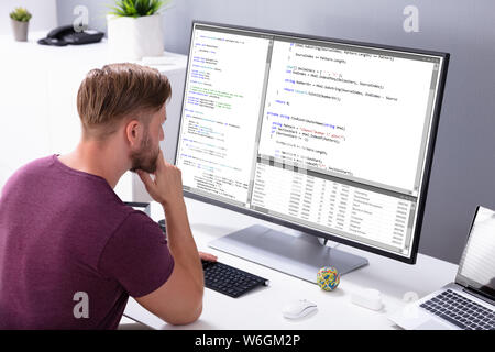 Man Programming Code On Computer In Office Stock Photo
