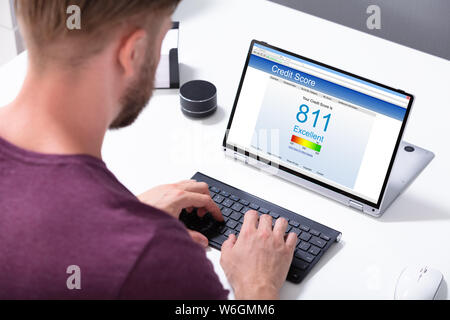 Young Businessman Checking Online Credit Score On Computer In Office Stock Photo