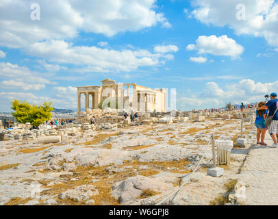 Tourists visit the ancient Erechtheion temple at the Athens Acropolis in Athens Greece on a warm summer day. Stock Photo