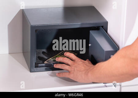 Close-up Of A Male Thief Stealing Banknotes From Open Safe Locker Stock Photo