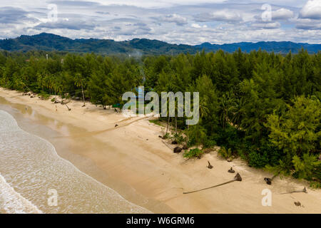 Aerial drone view of a beautiful empty tree lined tropical beach Stock Photo