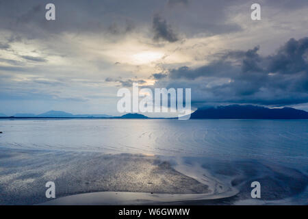 Aerial drone view of sunset and clouds over the ocean at low tide in Sarawak, Malaysian Borneo