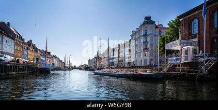 Tourist canal boat in the Canal at historic Nyhavn district  in Copenhagen, Denmark on 18 July 2019 Stock Photo