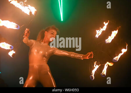 Brezje, Croatia - 19th July, 2019 : A woman juggling with a fire on the stage on the Forestland, ultimate forest electronic music festival located in Stock Photo