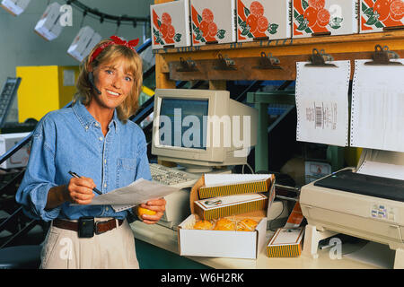 Woman working in an orange factory plant Stock Photo