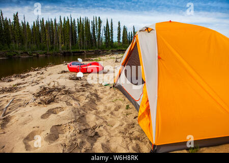 Tent and packraft on sandy beach on the Charley River on a sunny day, Yukon–Charley Rivers National Preserve; Alaska, United States of America Stock Photo