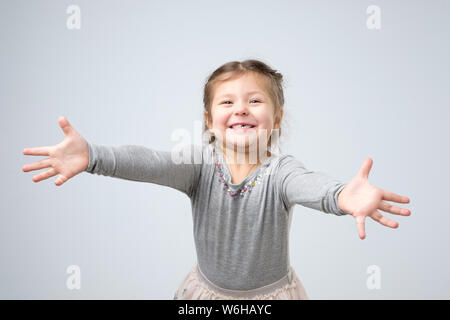 Female toddler stretching hands towards the camera, smiling from happiness Stock Photo