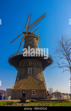 Leiden, Holland, Netherlands, April 21, 2019.  Street view, Molen De Valk museum (Falcon windmill) traditional houses parked bicycles and bicyclists Stock Photo