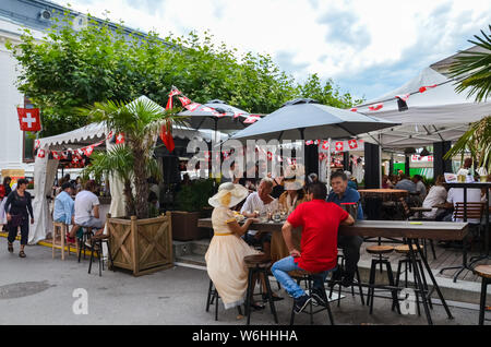 Vevey, Switzerland - Aug 1 2019: People celebrating Swiss National Day in outdoor restaurant. Celebration of the founding of the Swiss Confederacy. Independence day. Switzerland flags decoration. Stock Photo