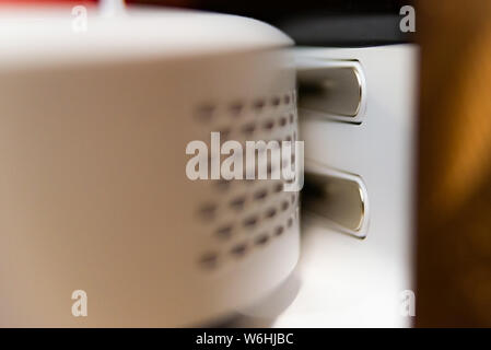Contacts of charging station of white robotic vacuum cleaner charging on base. Modern smart electronic housekeeping technology. Stock Photo