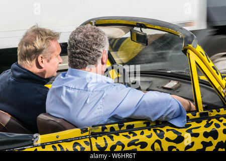 BERLIN, GERMANY - September 26, 2018: Tourist men riding a yellow car decorated with animal print at the urban trabi-safari tour near the East Side Stock Photo