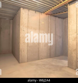 Square Interior of an empty building with concrete wall and corrugated metal roof Stock Photo