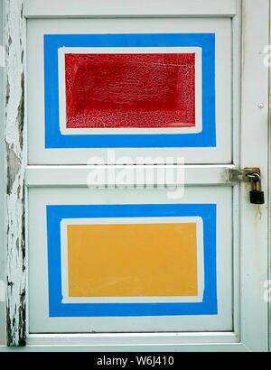 An old wooden door with red amd yellow painted rectangles Stock Photo