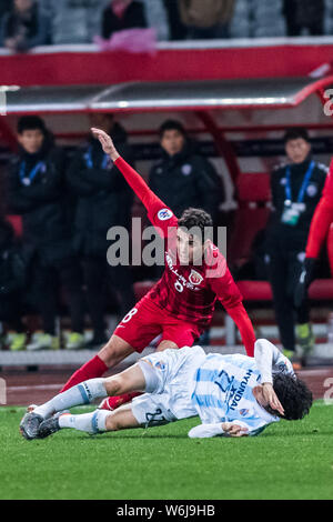 Brazilian football player Oscar, back, of Shanghai SIPG, challenges Cao