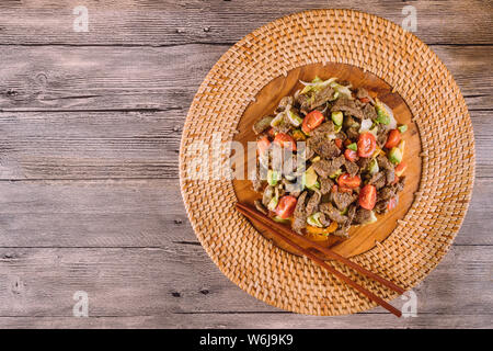Asian Food: Bulgogi beef slices fried with sesame and carrot on a plate. Horizontal top view Stock Photo