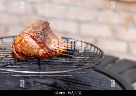 Close-up of a marinated rack of lamb being cooked on an outdoor grill. Stock Photo