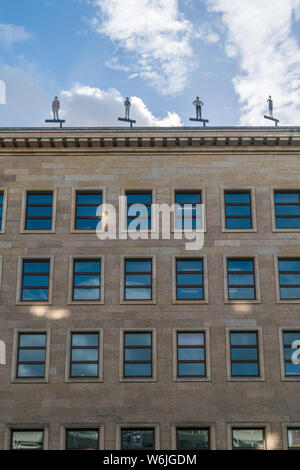 BERLIN, GERMANY - July 28, 2018: Upwards perspective of the Former Reichsbank building, an example of the historical Nazi architecture, and its human Stock Photo