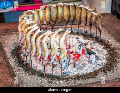 Grilled fish over fire at a food stall, Hanami Fest, Ueno Park, Tokyo, Japan Stock Photo