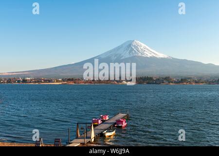 Footbridge with pedal boats, view over Lake Kawaguchi, back volcano Mt. Fuji, Yamanashi Prefecture, Japan Stock Photo