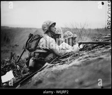 Observer who spotted a machine gun nest finds its location on a map so they can send the information to artillery or mortars to wipe out the position. Iwo Jima, February 1945.; General notes:  Use War and Conflict Number 1218 when ordering a reproduction or requesting information about this image. Stock Photo